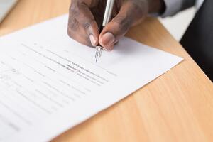 a man signing a contract | Collection services Michigan