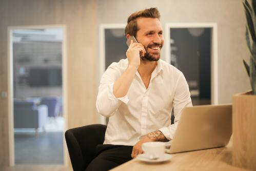 Business man smiling on the phone | Debt collection Michigan