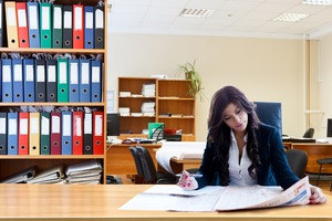 A woman working at a desk | Collection Services Michigan