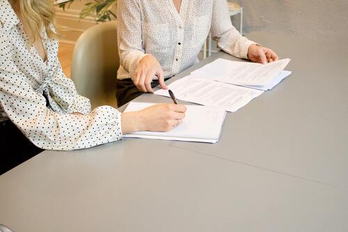 Two people looking at documents | Collection companies Michigan