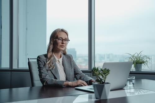 A woman sitting at a desk on a computer | Collection companies Michigan