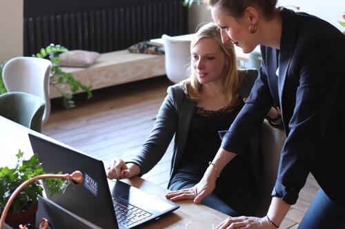 Two people looking at a computer in an office | Collection Services Michigan